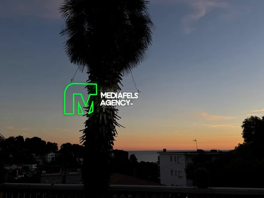 Rótulo de neón de Mediafels Agency al atardecer en Castelldefels